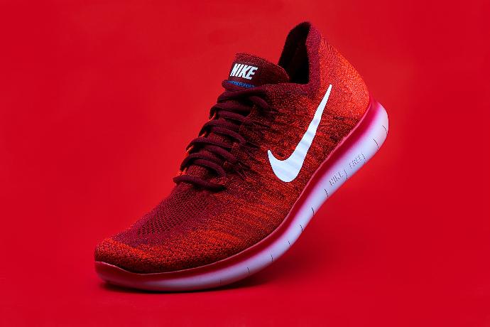 unpaired red Nike sneaker